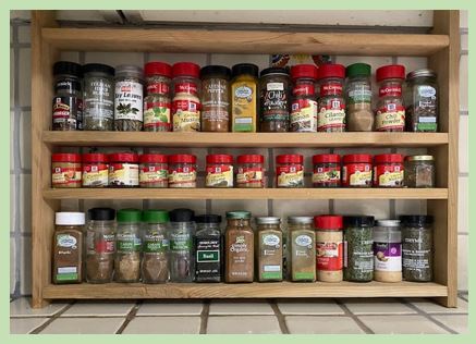 The photo depicts a small kitchen spice rack. There are three shelves of different heights to fit spice bottles of different heights.